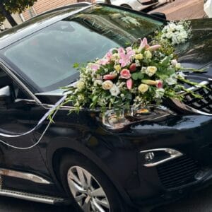 Lina Çiçekçilik tarafından canlı çiçeklerle hazırlanan siyah SUV gelin arabası süslemesi. Beyaz çiçekler, doğal yeşillikler ve rustik kapı süsleriyle lüks düğün aracı.